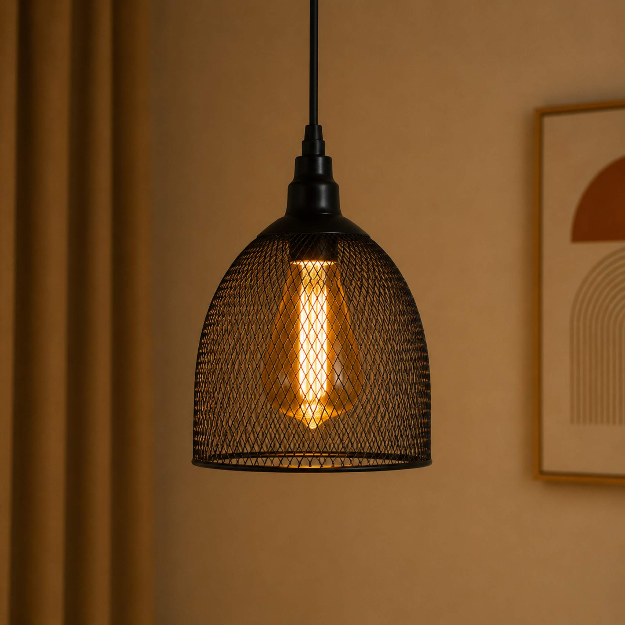 Black wire mesh pendant light hanging against a beige wall with a framed picture.