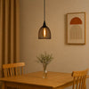 Dining room with wooden table, chairs, hanging light fixture, and wall art.