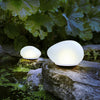 Modern waterproof pebble-shaped garden lights accentuating a backyard rockery feature.